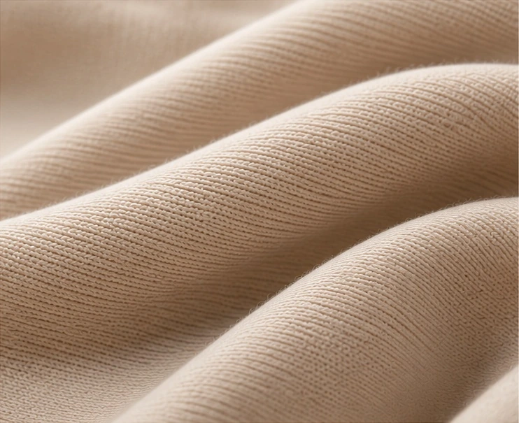 Close-up of smooth cream knit fabric.