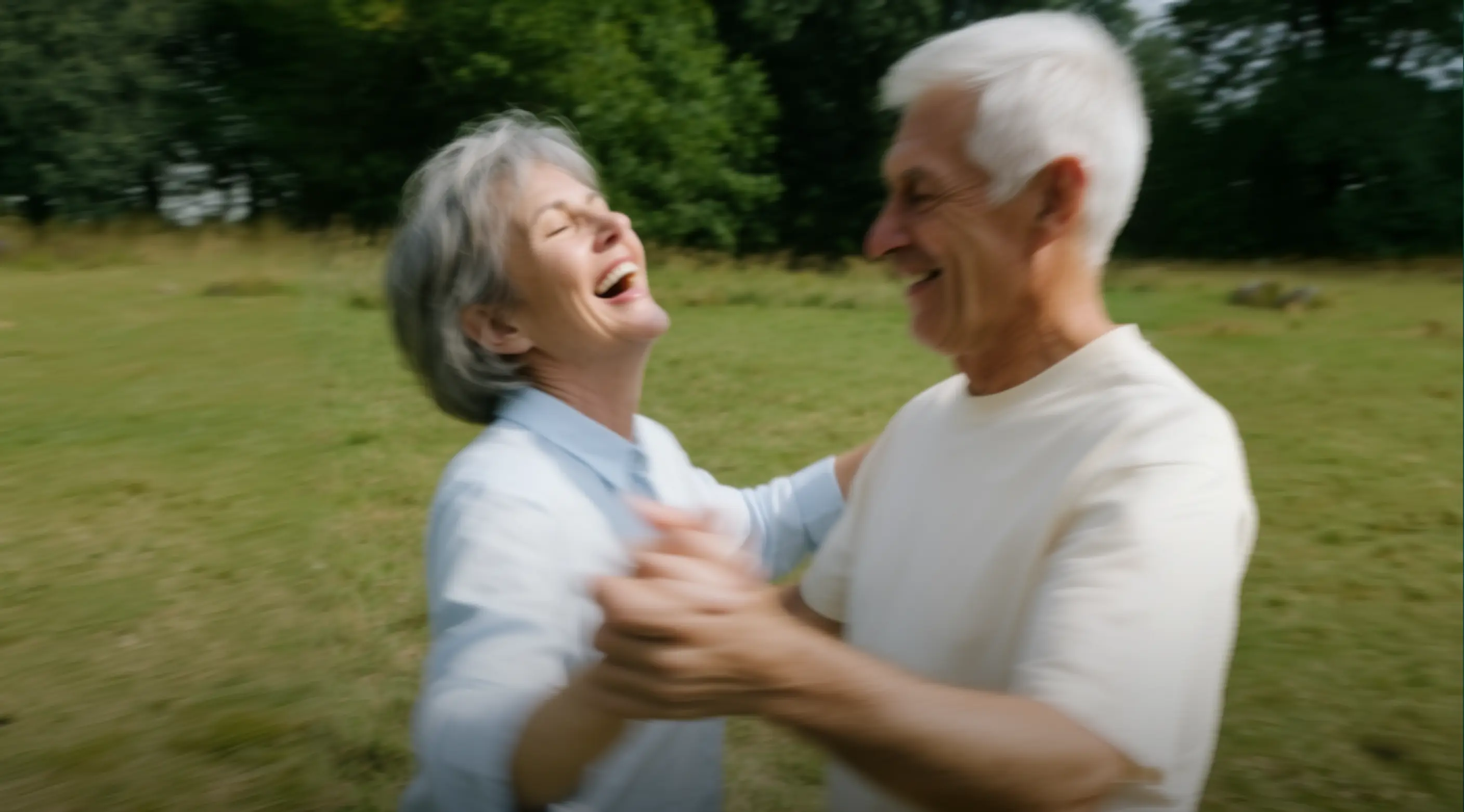 Older couple laughing and dancing together outdoors