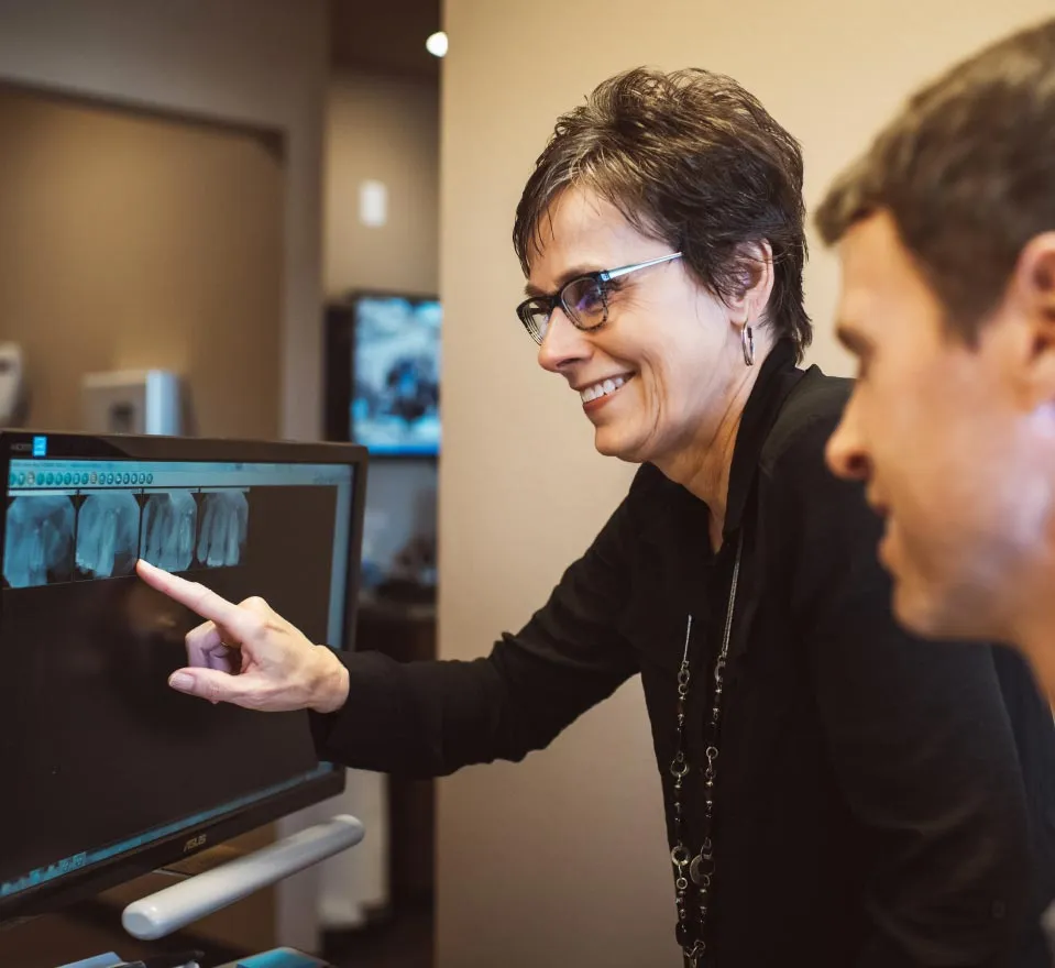 Dental hygienist showing a patient's x ray at Loftus Dental