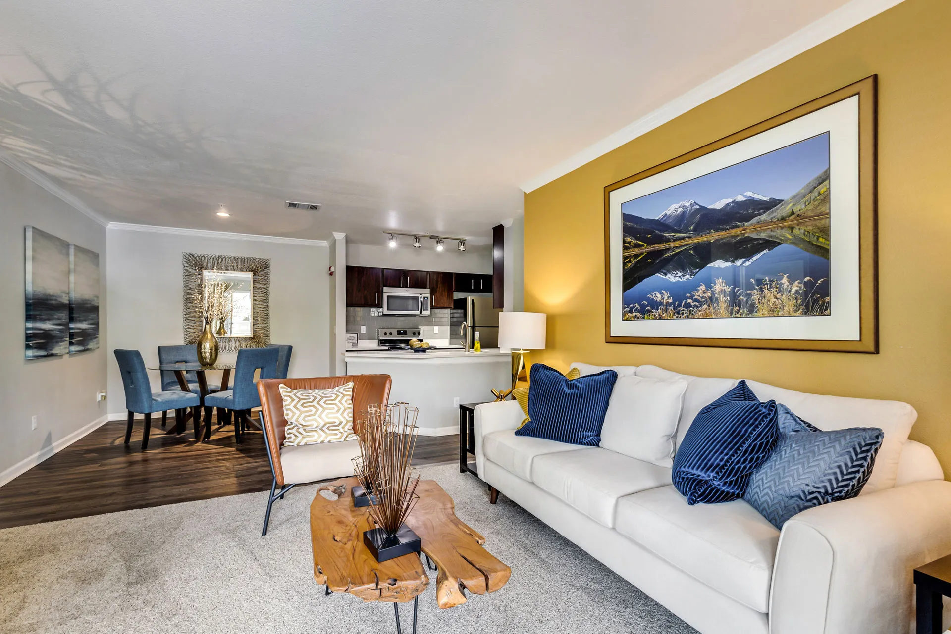 furnished living area with sofa, coffee stable and view into kitchen