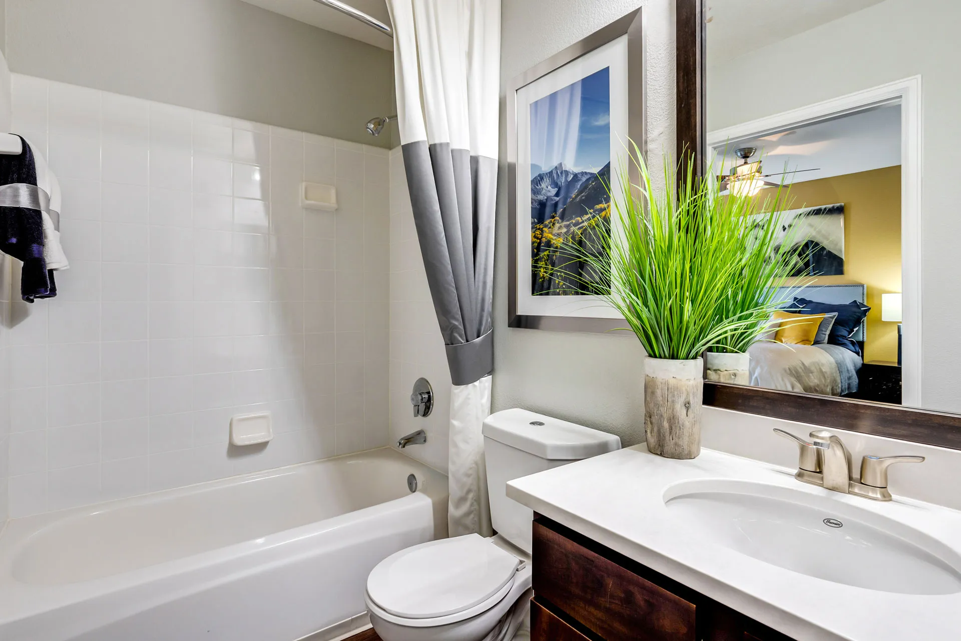 bathroom with tub and decor of wall art and plant