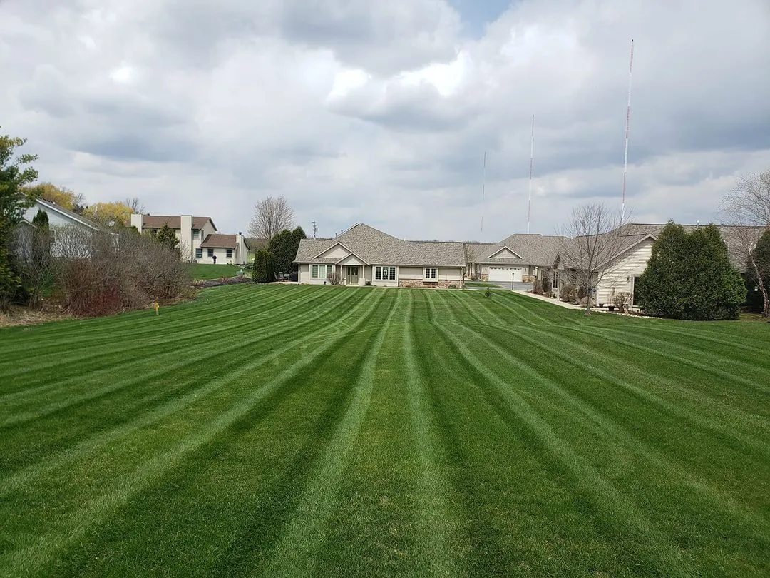 A professional providing lawn care services to homeowners in Grafton, WI