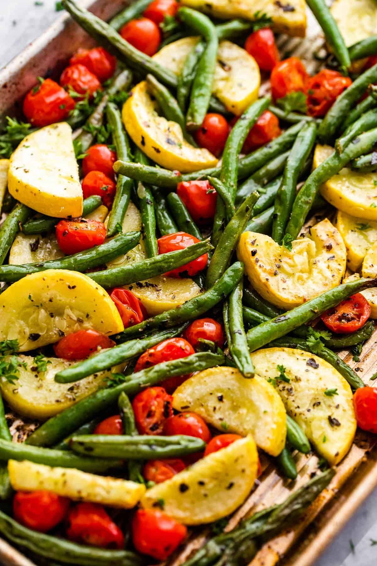 Roasted summer vegetable medley with cherry tomatoes, green beans, zucchini, and basil