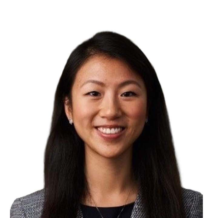 Smiling young woman with long dark hair wearing a blazer and necklace.