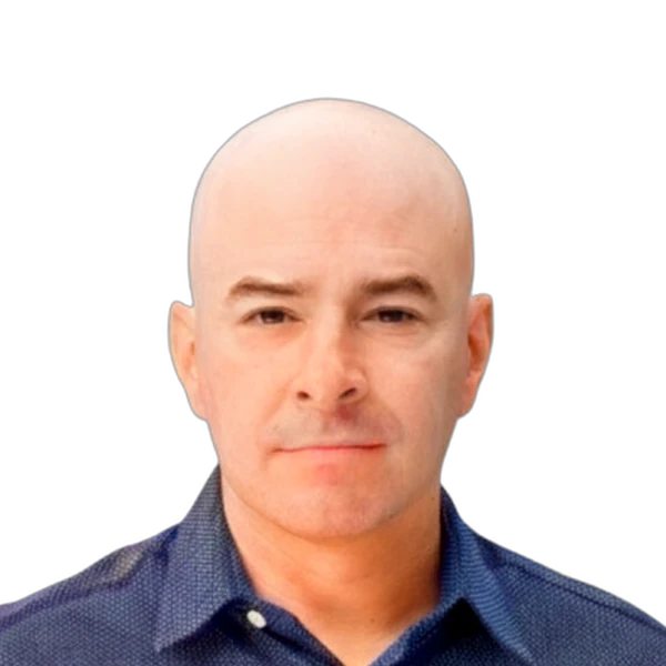 Portrait of a bald man wearing a dark patterned button-up shirt against a white background.