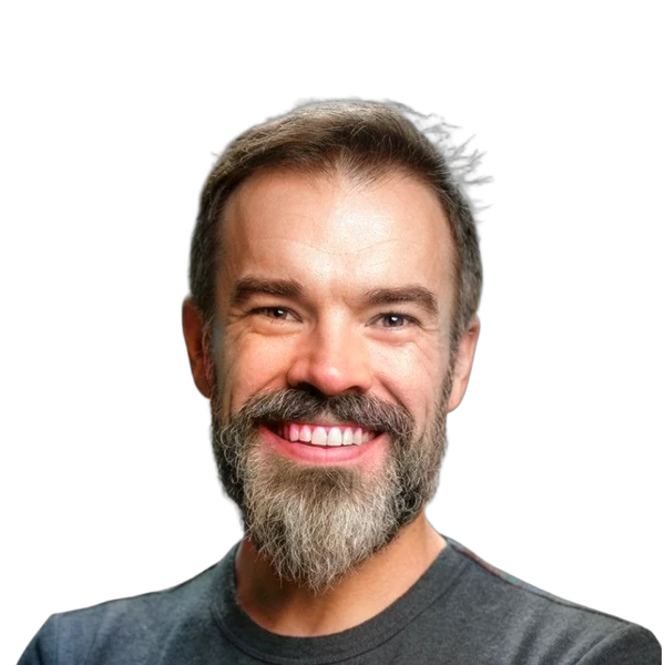 Smiling man with beard and mustache wearing a dark shirt.
