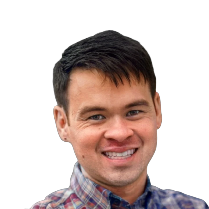 Smiling man with dark hair wearing a plaid shirt.