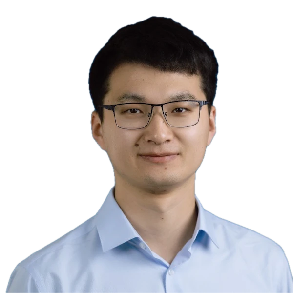 Headshot of a smiling man with short dark hair and glasses, wearing a light blue collared shirt.