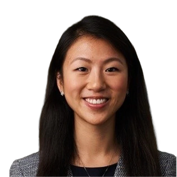 Headshot of a smiling woman with long dark hair, wearing a dark blazer.