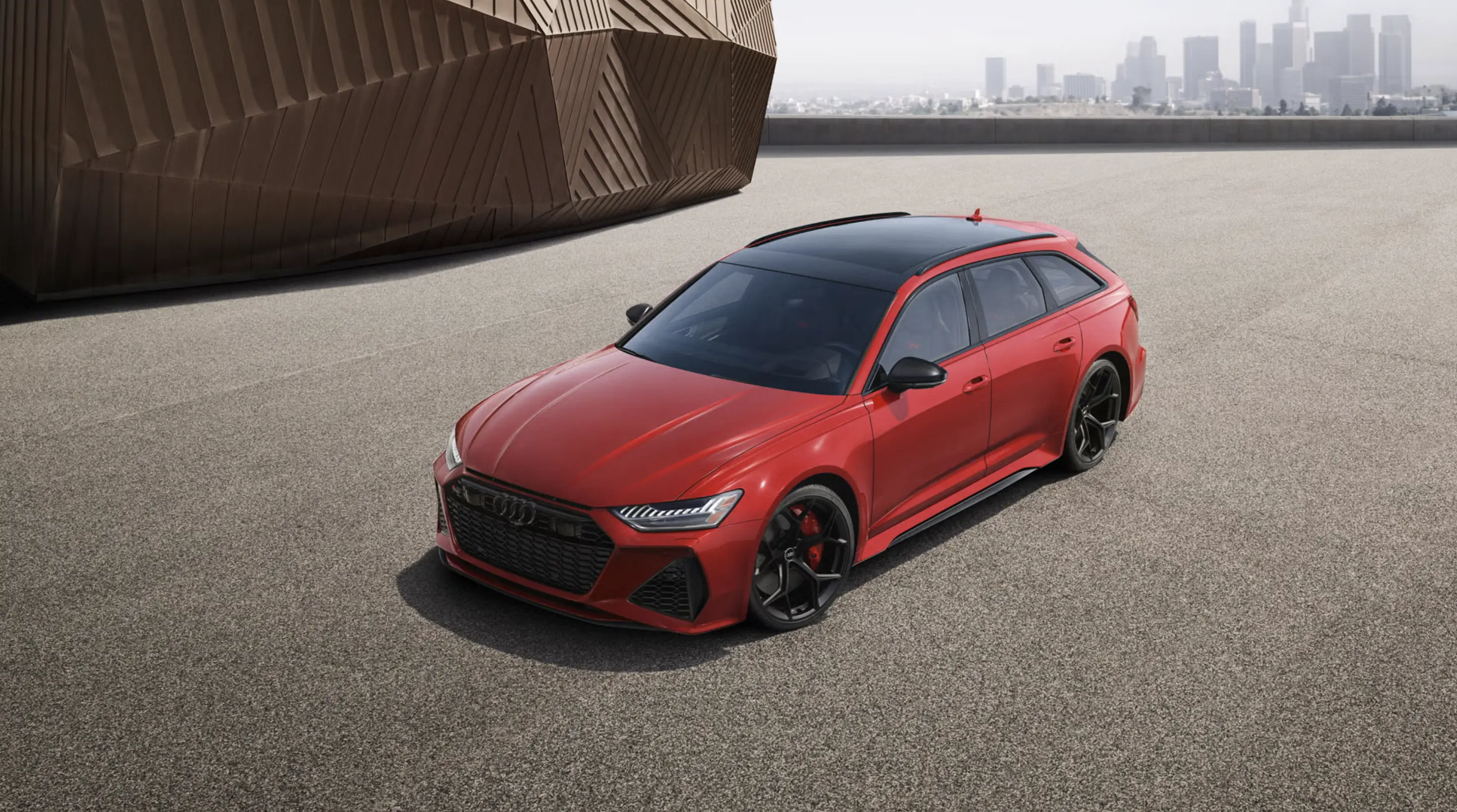 Red Audi subcompact parked in front of a cityscape.
