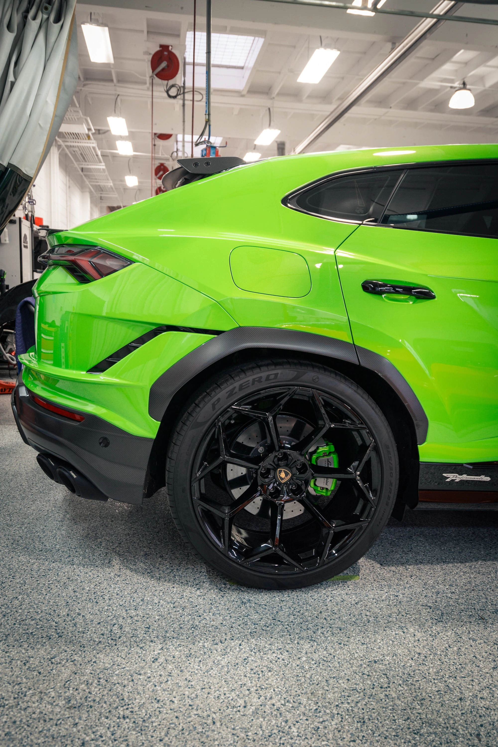 Rear fender and wheel of a green Lamborghini Performante inside the Barsotti's Body and Fender shop.