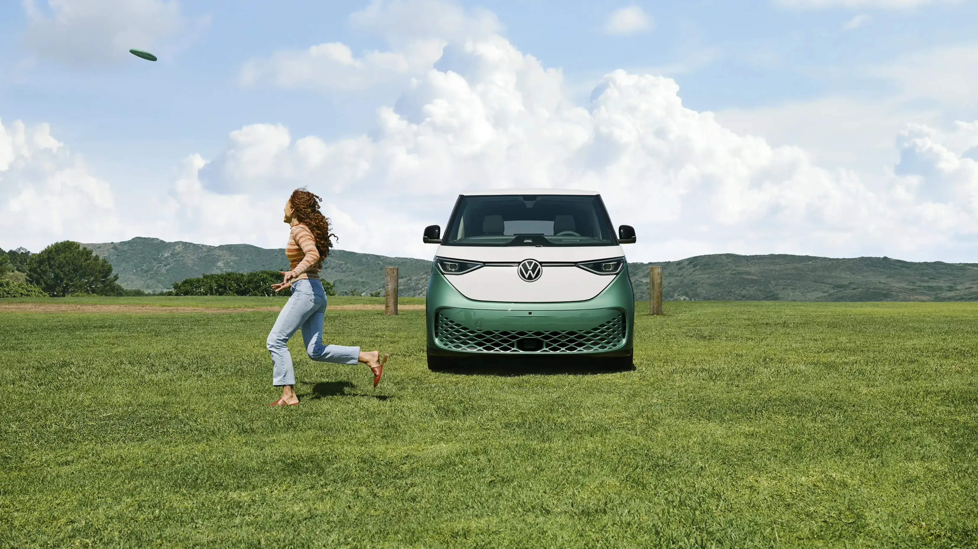 Woman running next to a green and white Volkswagen ID.BUZZ.