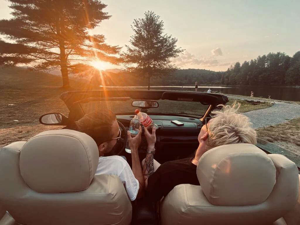 Jóvenes viajando en un auto descapotable al atardecer durante su intercambio en Estados Unidos