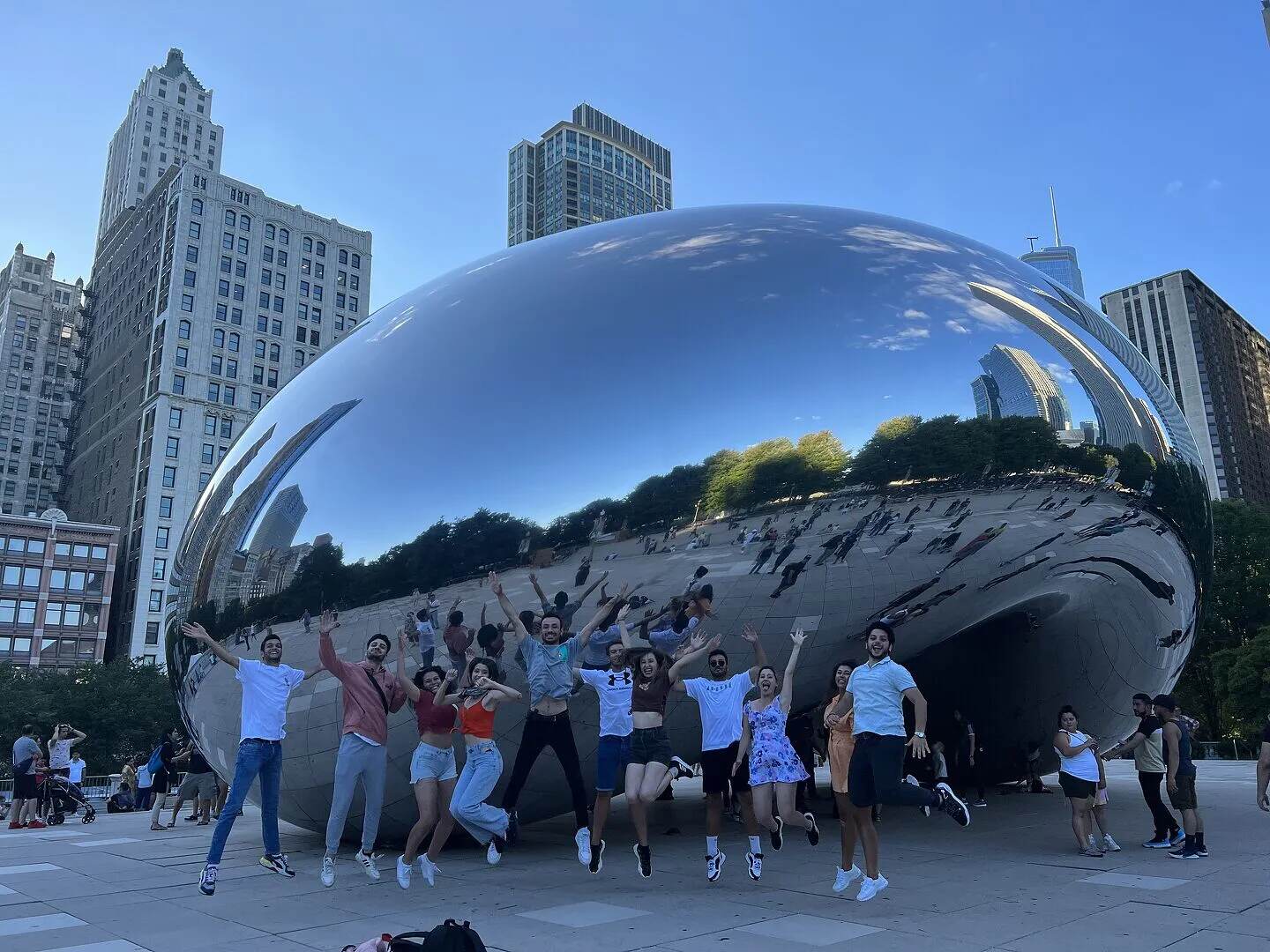 Grupo de estudiantes Work and Travel saltando frente al Cloud Gate en Chicago