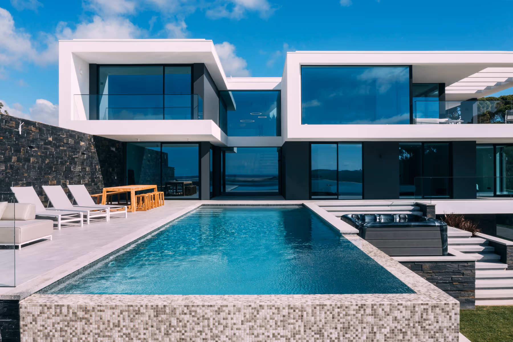 Sea Insight Villa exterior front facade with dark stone base and panoramic glazing