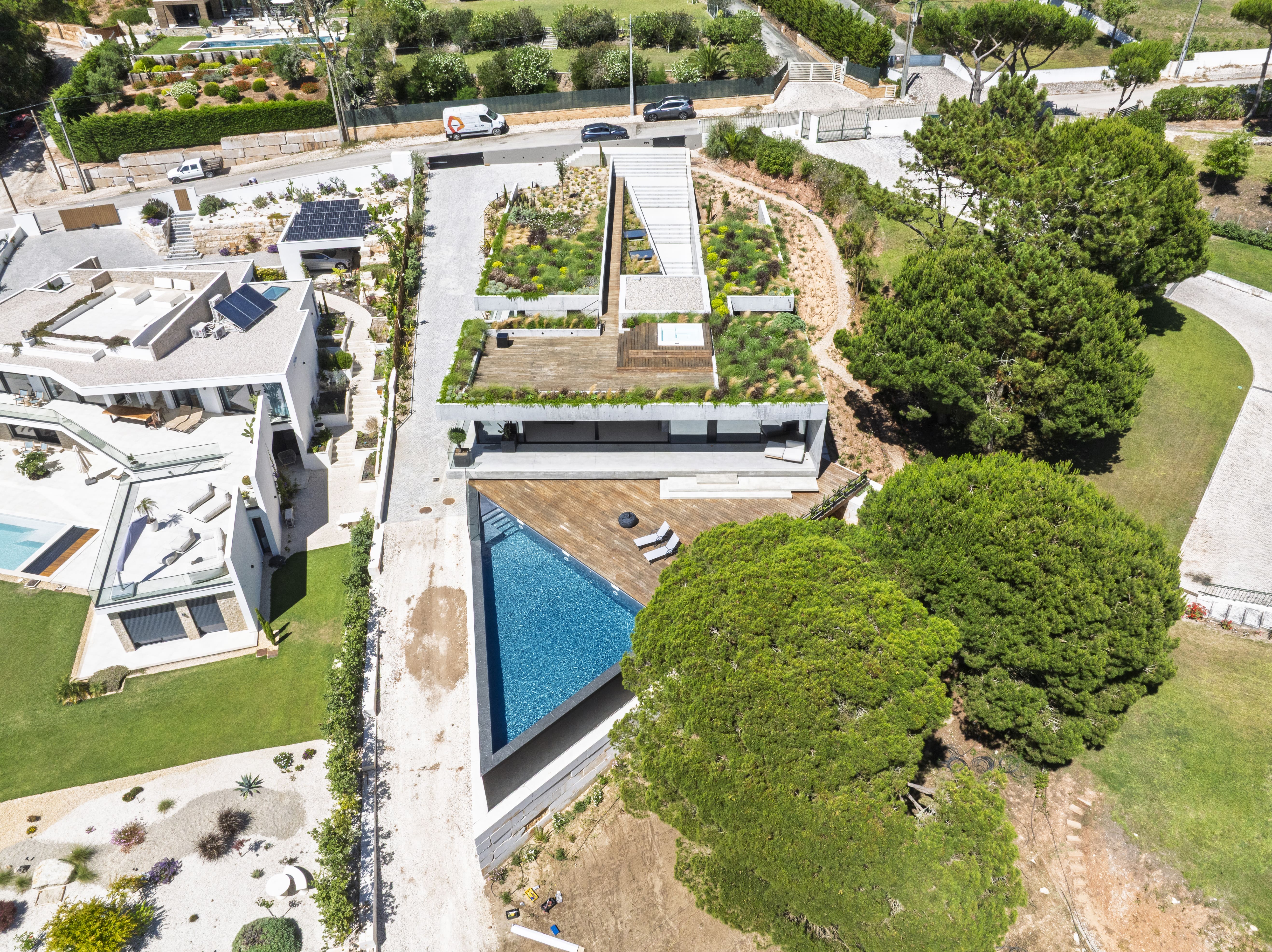 Triangular Hillside Villa drone view showing angular roof planes and pool terrace