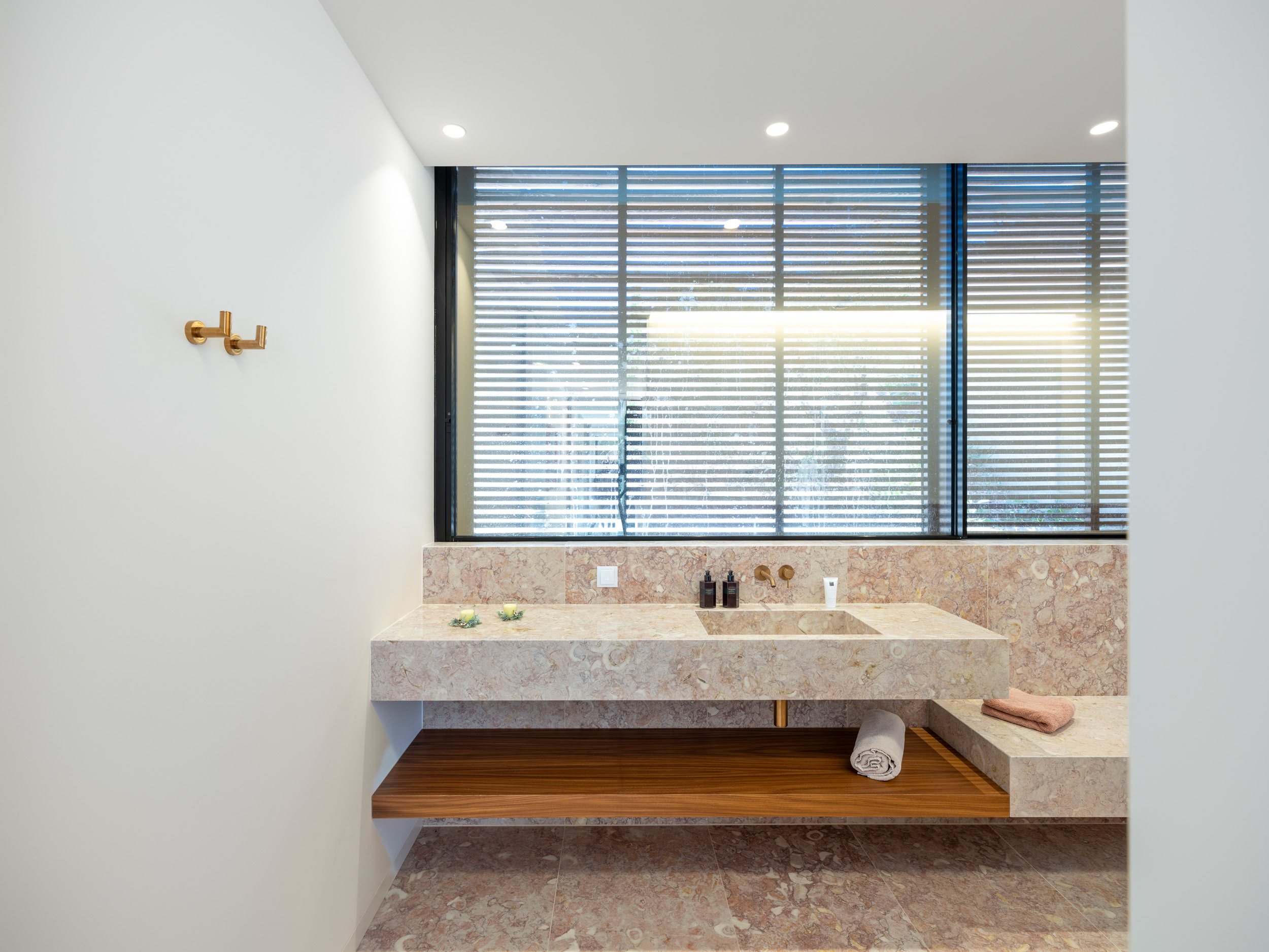 Triangular Hillside Villa Lioz stone bathroom interior and micro-cement luxury finishes