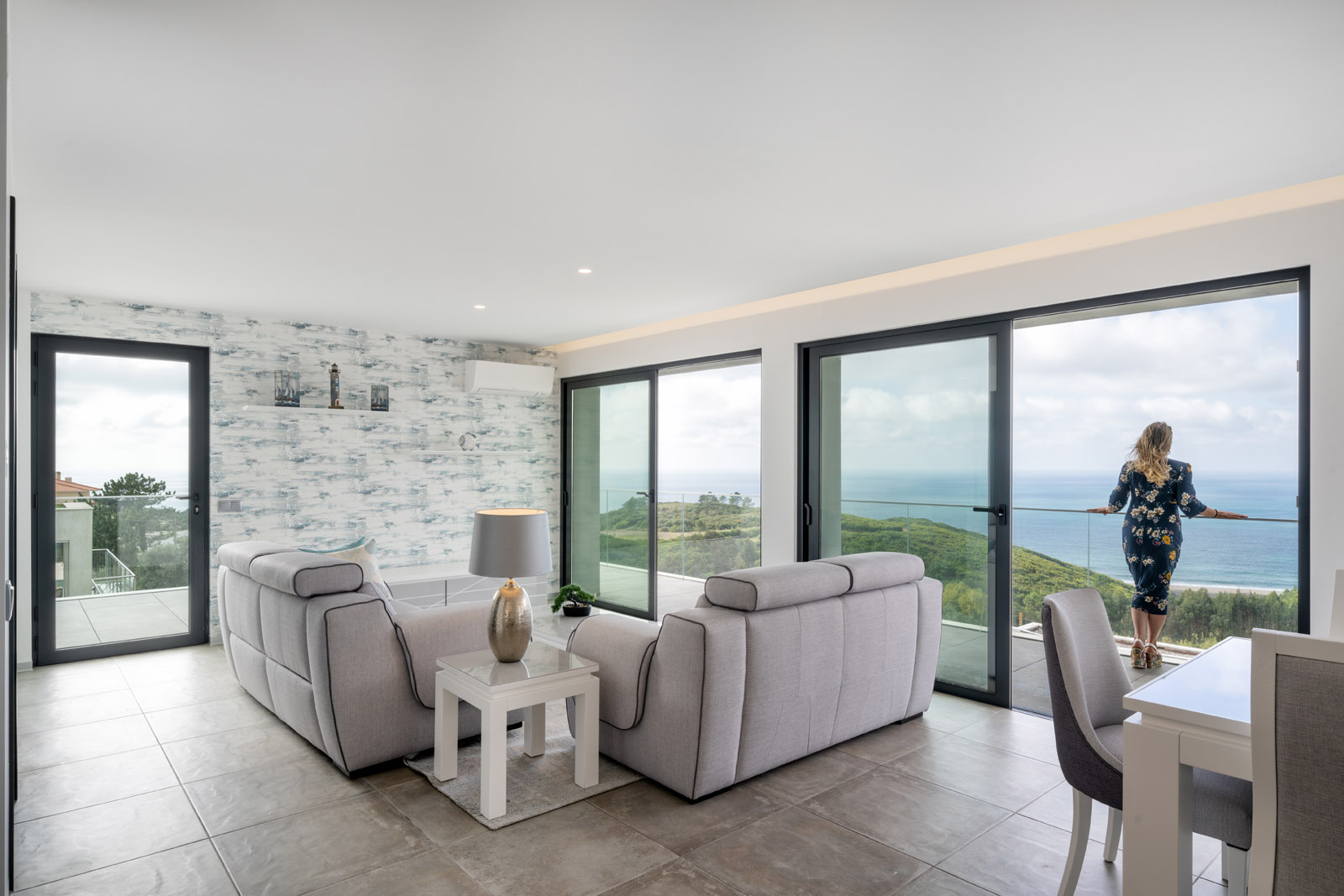 Fishing Ridge Villa living area with floor-to-ceiling windows framing Atlantic coastal views