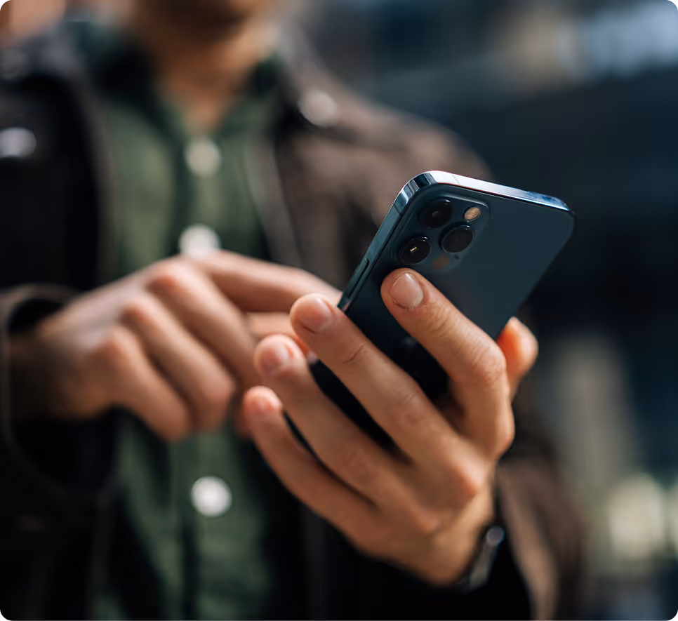 Person holding and using a modern smartphone with three camera lenses on the back