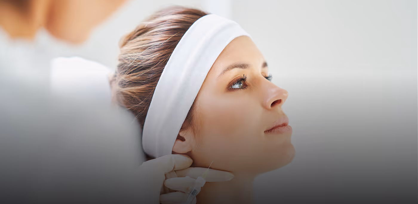 Close-up of a woman wearing a white headband receiving a cosmetic injection in the face for Medsen brand