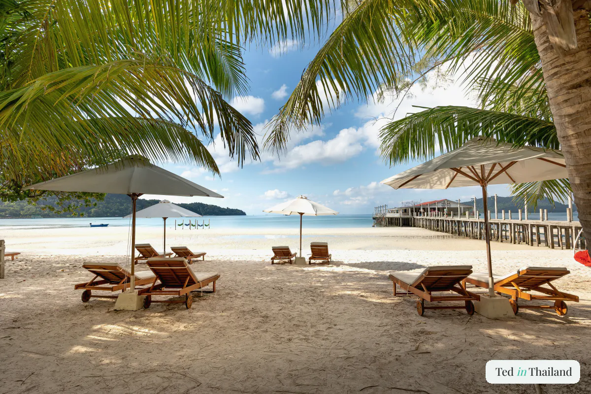 A Koh Samui beach with sparkling water, white sand and wooden beach chairs