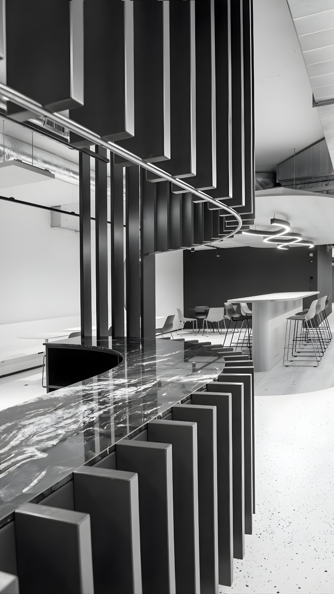 Modern office interior with a curving marble counter and sleek black vertical panels.
