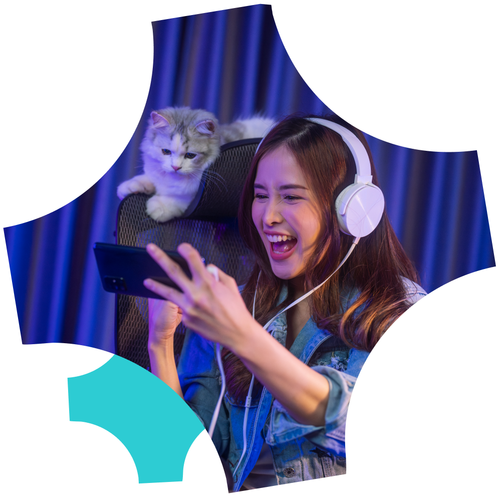 a female teenager playing video game with a cat pet beside her