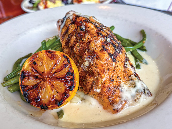 a plate of salmon with bur blanc sauce