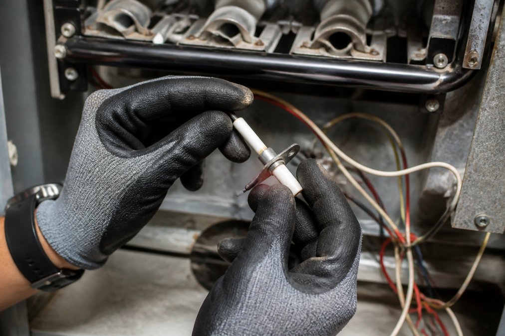Step-by-step guide on cleaning a furnace flame sensor to fix a furnace blowing cold air by removing the metal rod.
