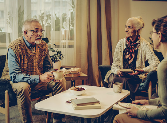 Retirees hanging out in a living room talking