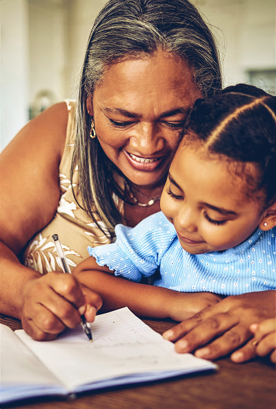 Retired woman coloring with her grandchild