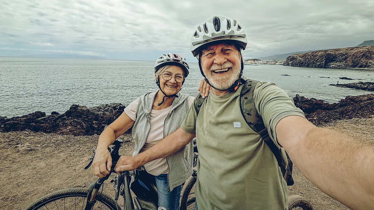 Retired couple on a bike ride along the ocean
