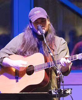 A guitar player on stage during a service