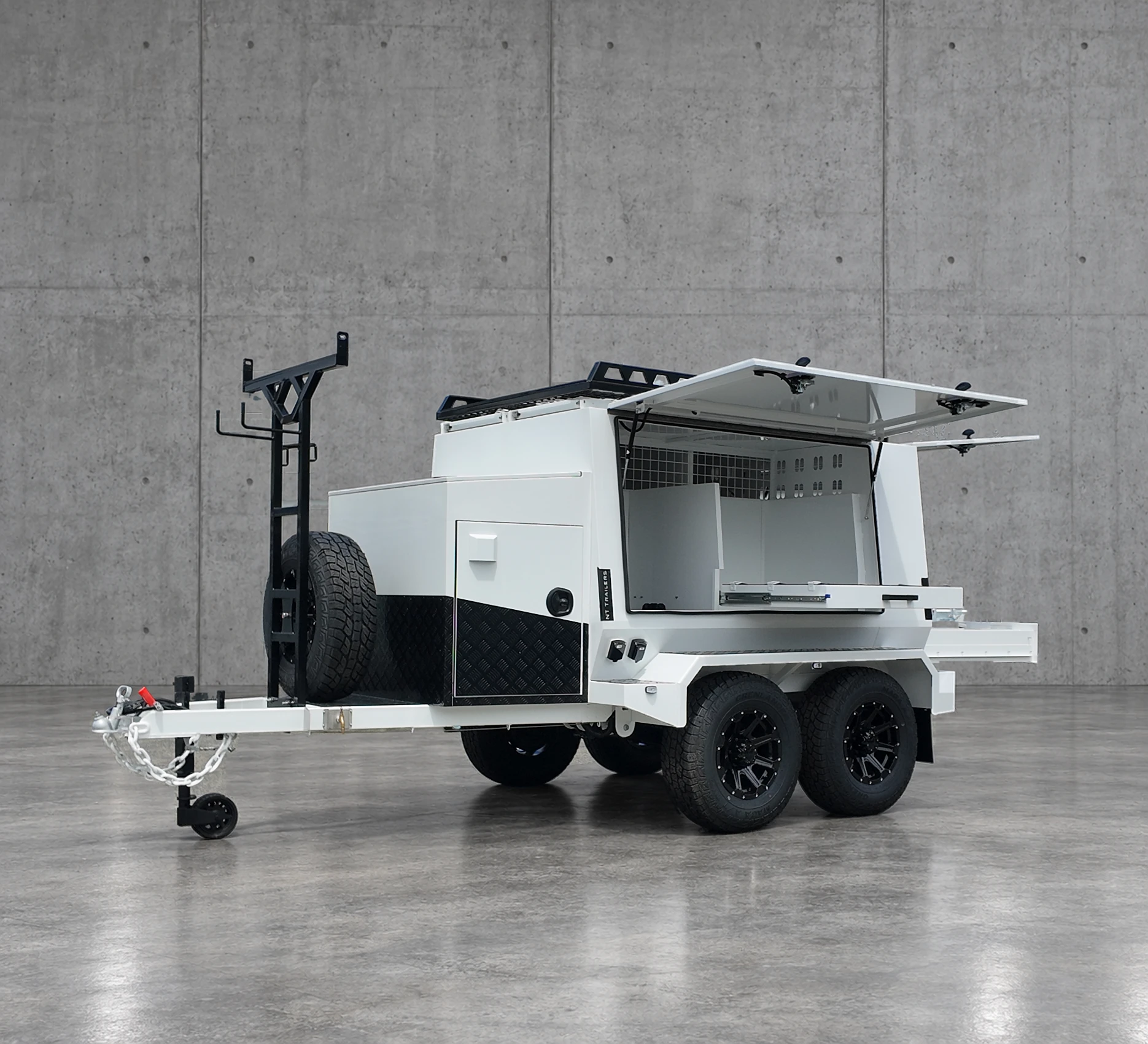 White Tradesman trailer with gull-wing doors open, showing the shelving and slide-out tray