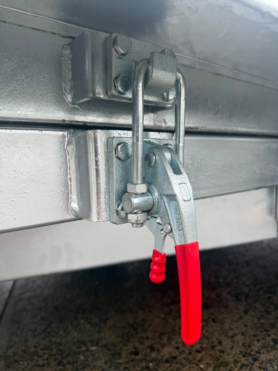 Tipper trailer body latch locked, with the hook over the catch and the red handle down