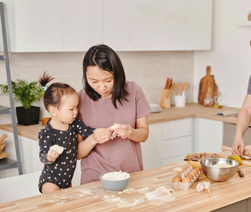 A mother and small child baking in the family kitchen.