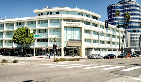 Street view of a white multi-story medical office building at the intersection of Loma Vista Drive and Linden Drive on a sunny day.