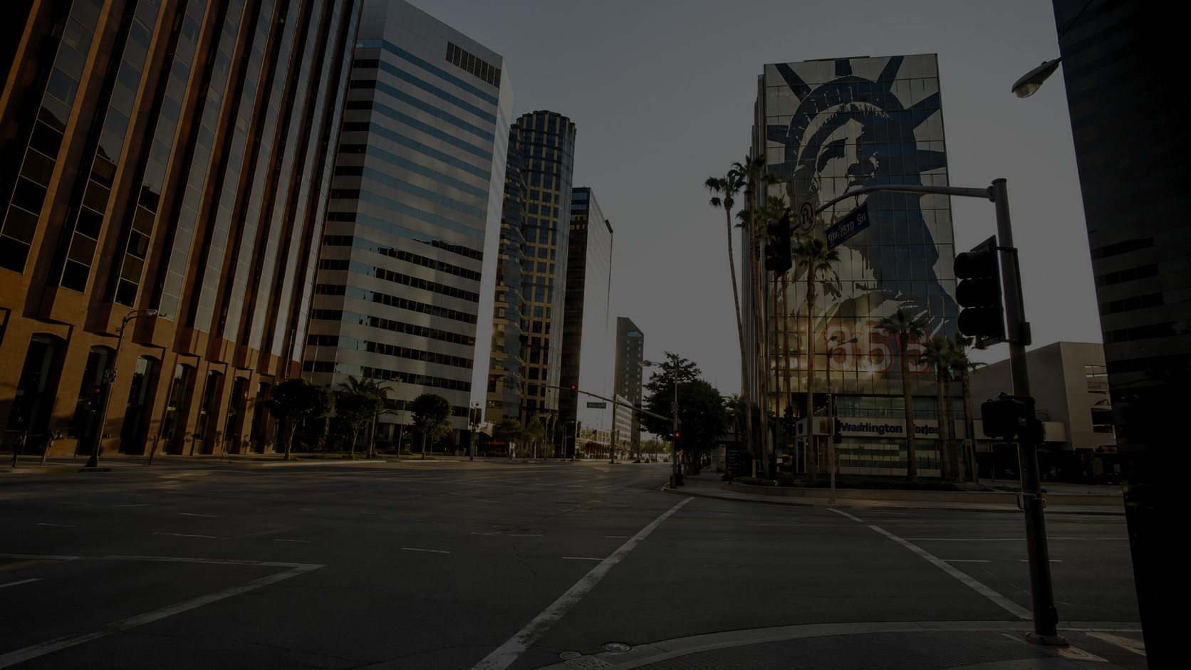 Modern shopping center named Encino Place with shops, outdoor seating, a fountain, and palm trees.