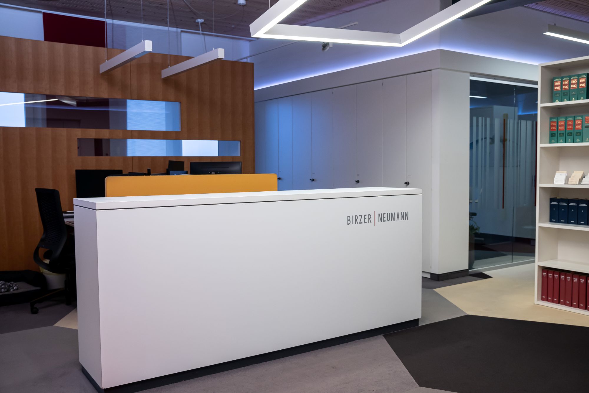 Moderner Empfangstresen in Büro mit Beleuchtungselementen.