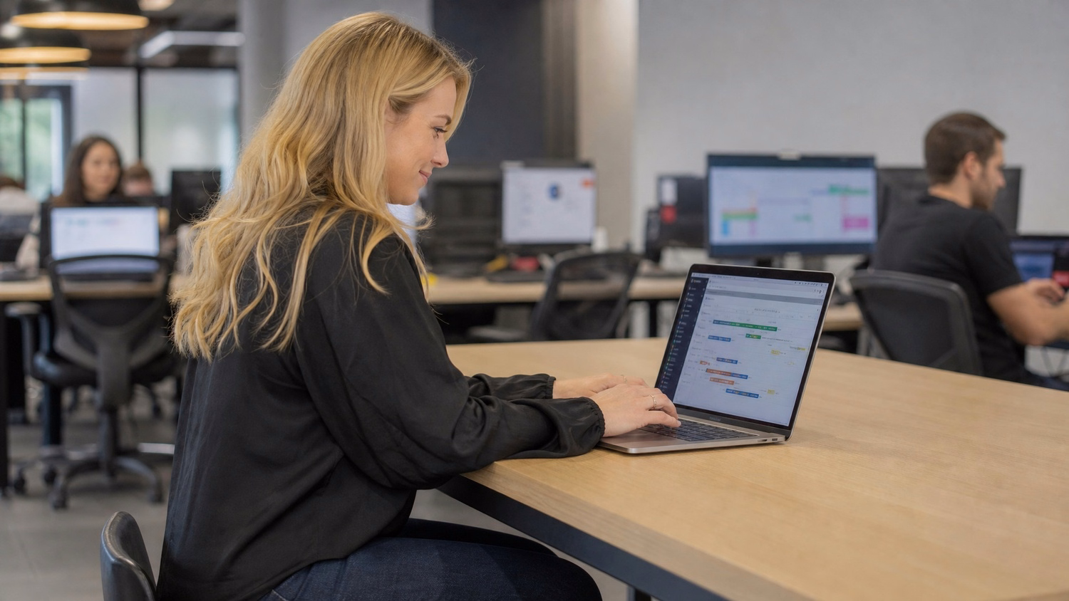 Woman at bar-height desk mapping IT strategy on laptop
