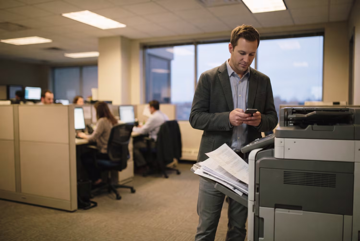 Security team member standing by office printer dispensing papers