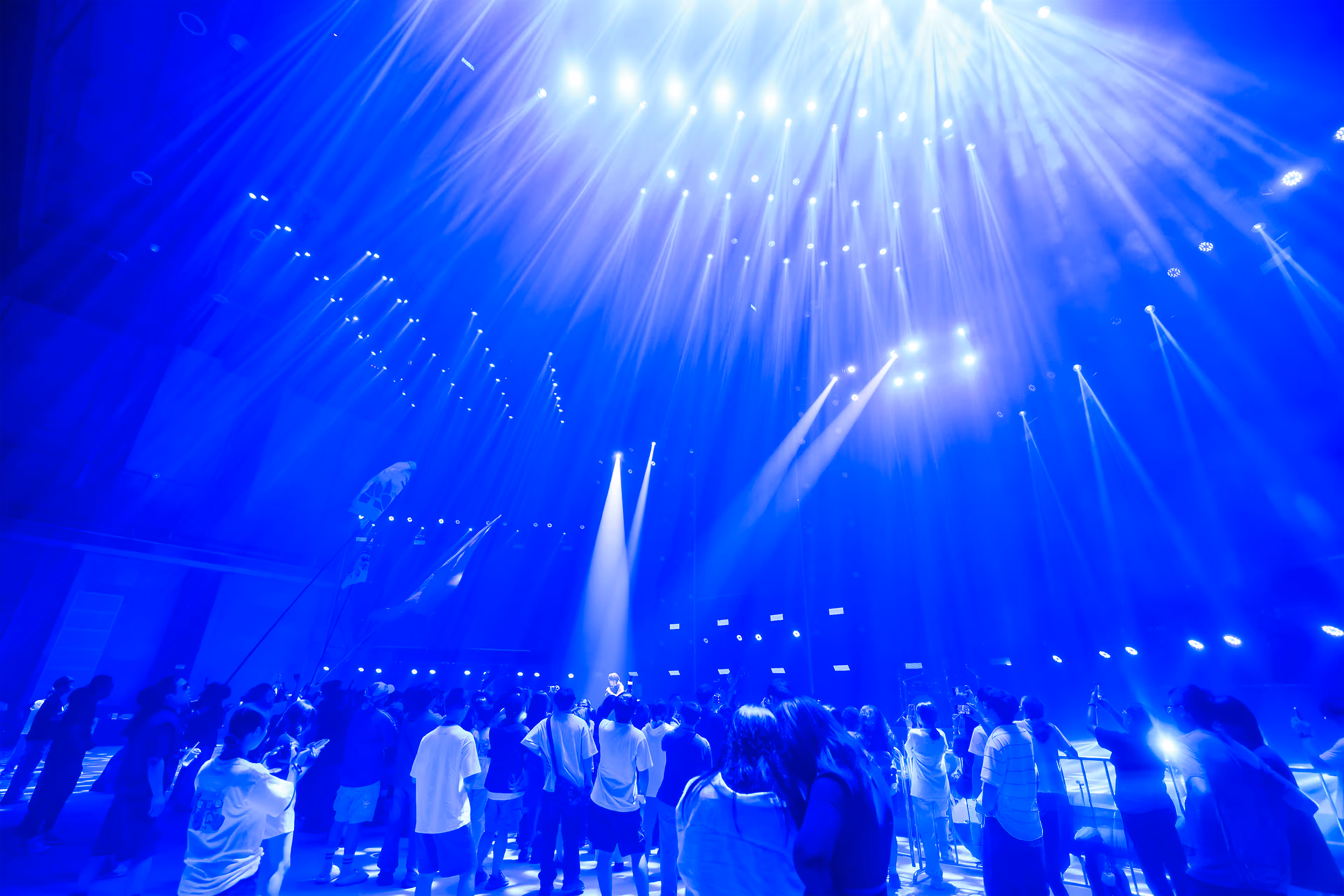 Crowd of people at a concert or event under bright blue stage lights and spotlights - at AltNext Edition 1 in 2025.