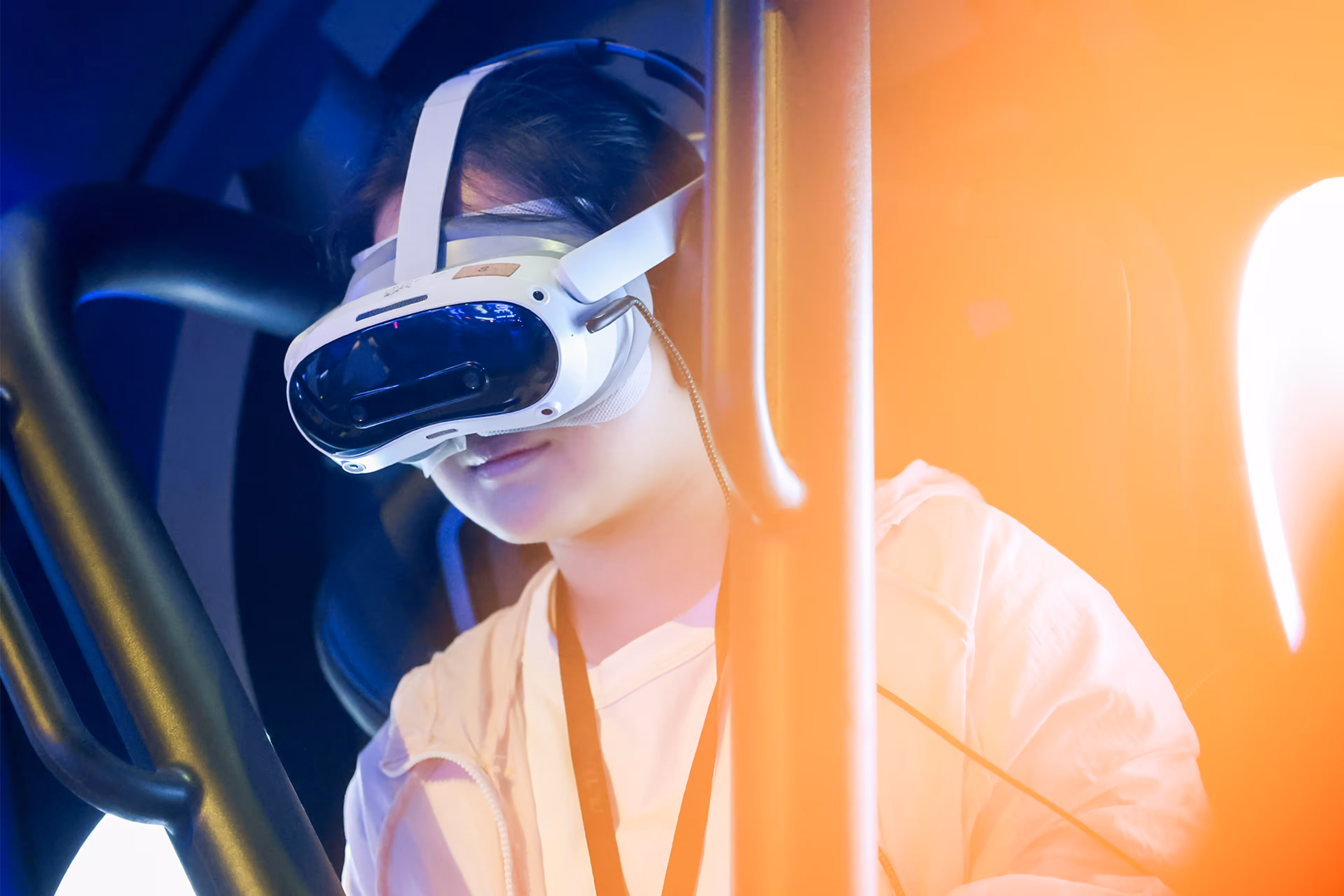 Person wearing a white VR headset with straps, immersed in virtual reality with blue and orange lighting - at AltNext Edition 1 in 2025.
