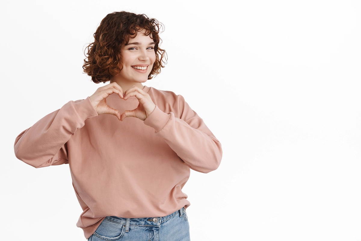 Femme montre coeur je t'aime signe, complimente, exprime sa sympathie ou aime, debout sur blanc | Freepix