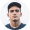 Jeune homme aux cheveux courts et t-shirt noir, fond neutre gris.