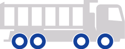 Silhouette of a truck trailer with eight blue wheels on a construction site.
