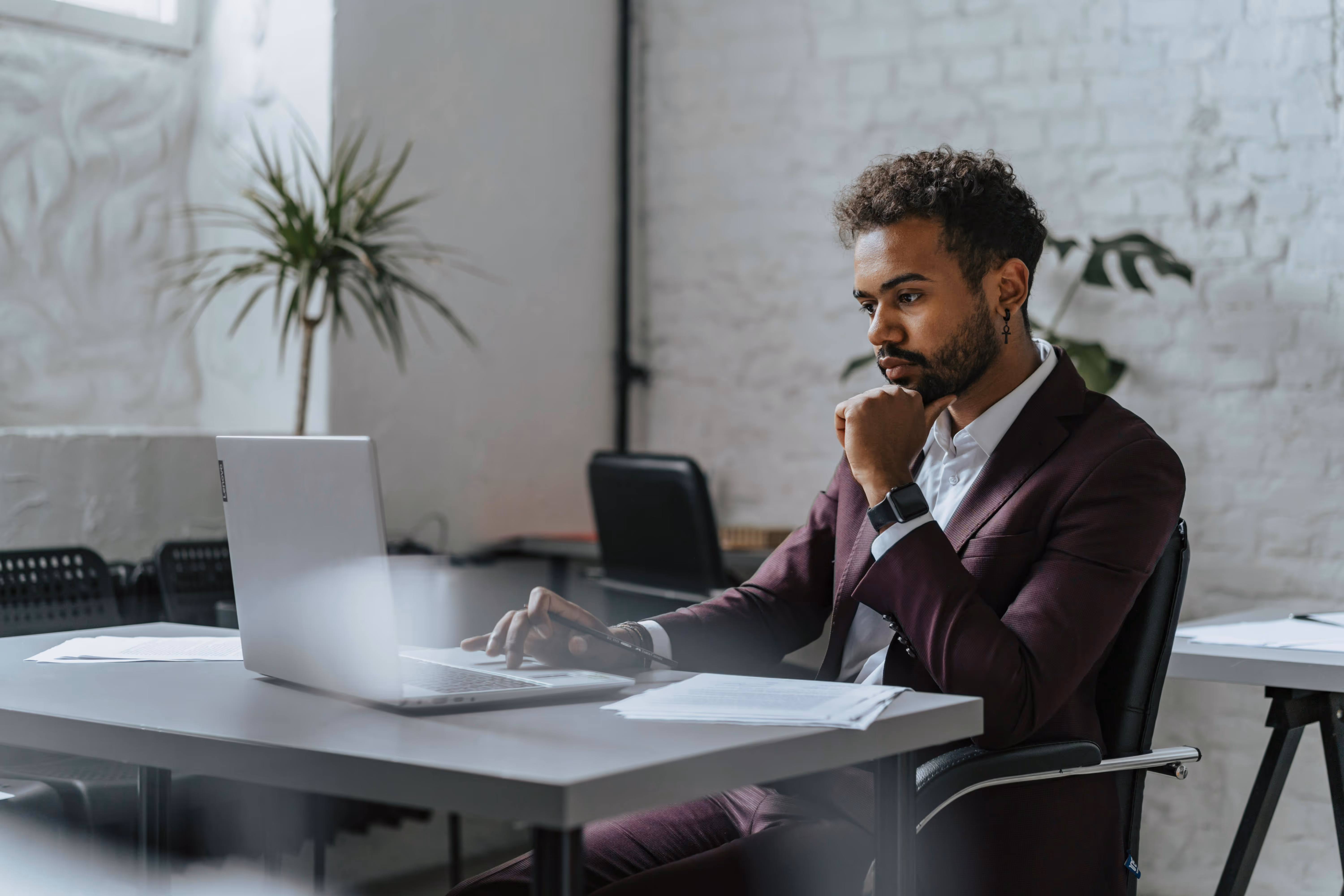 Professional man working on a laptop in a modern office, representing skilled migration, career opportunities, and professional relocation.