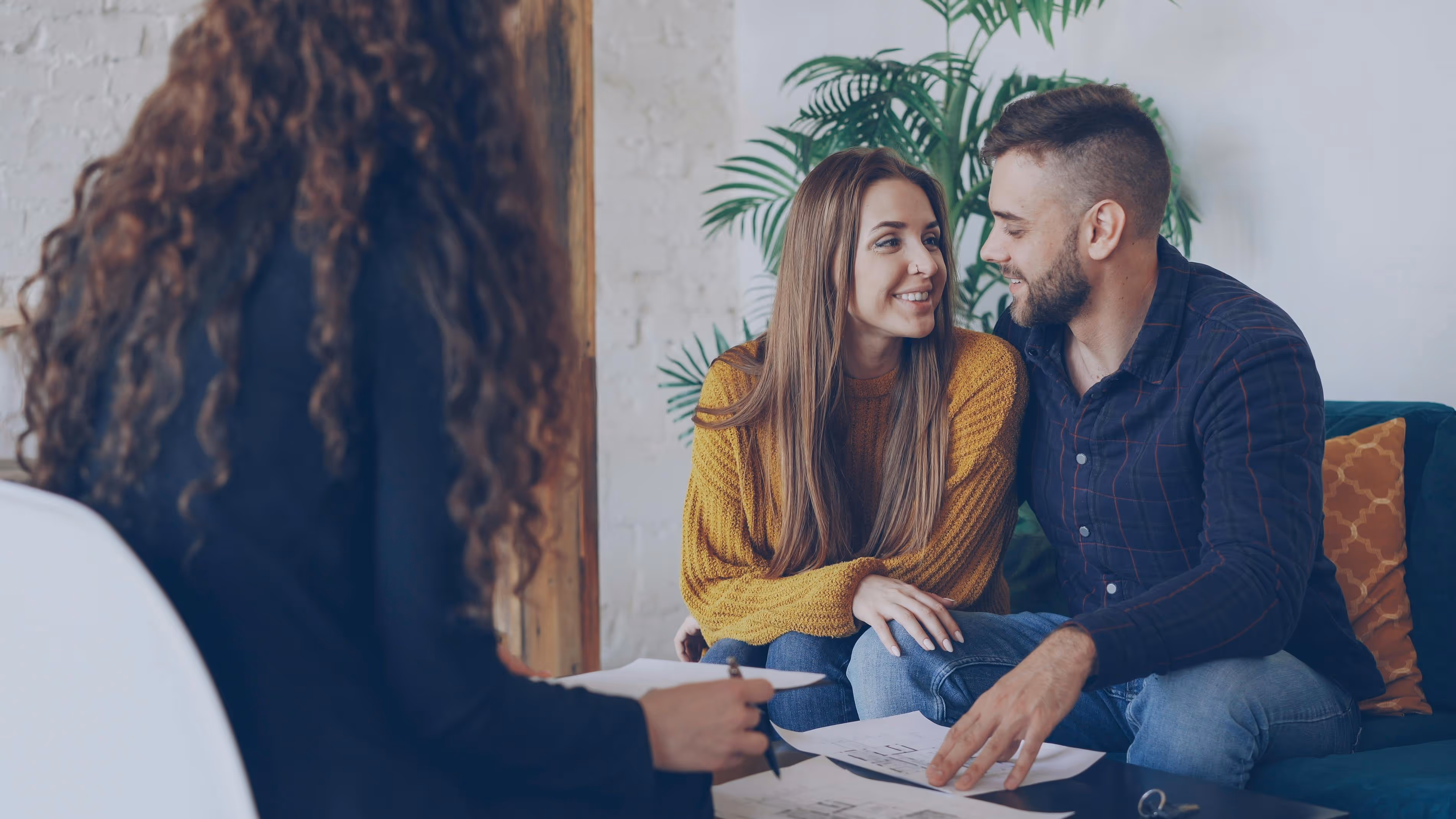 Couple meeting with a consultant and reviewing documents, representing partner visa applications and relationship assessment in Australia.