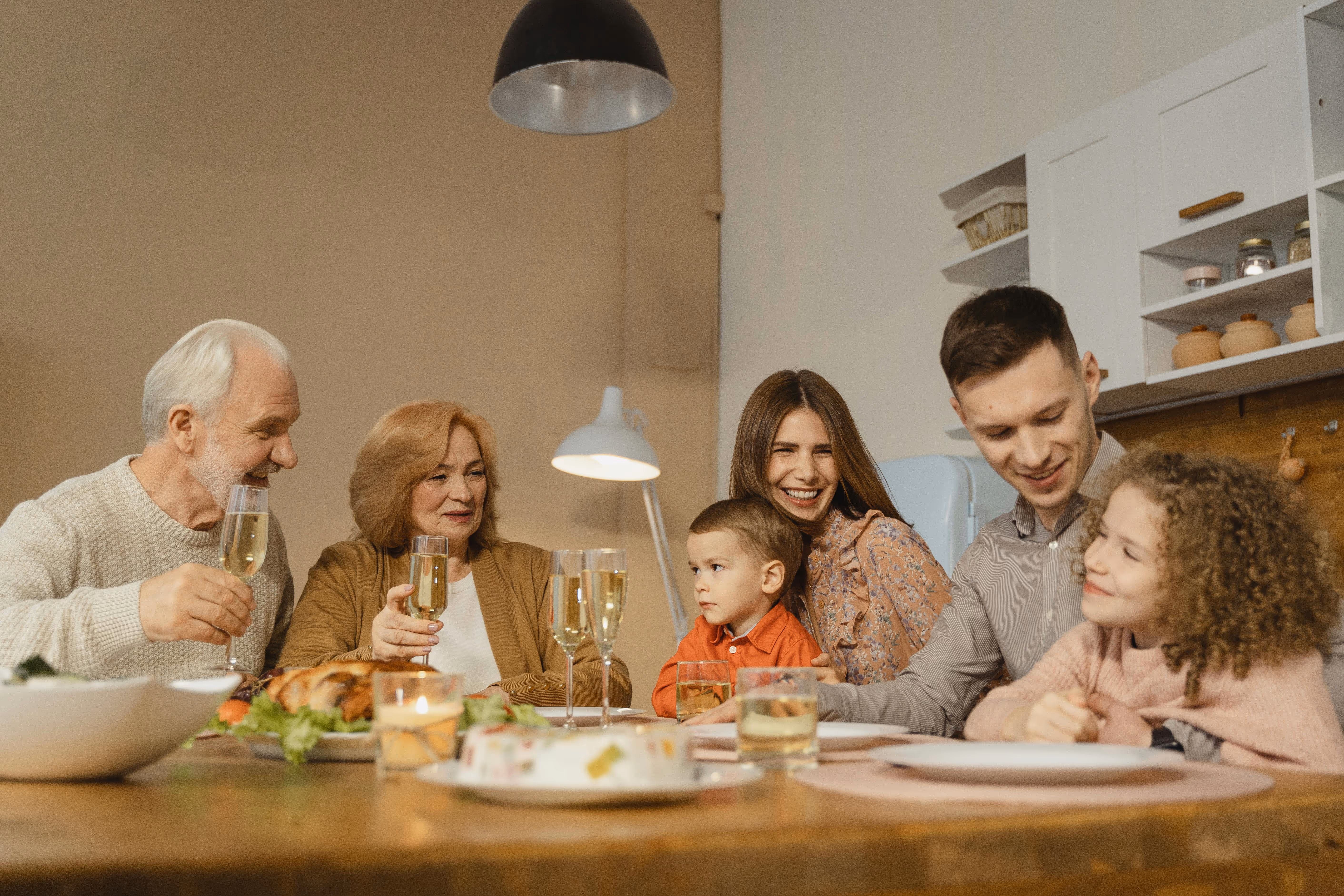 Extended family sharing a meal together at home, symbolising family reunification, support, and life together in Australia.