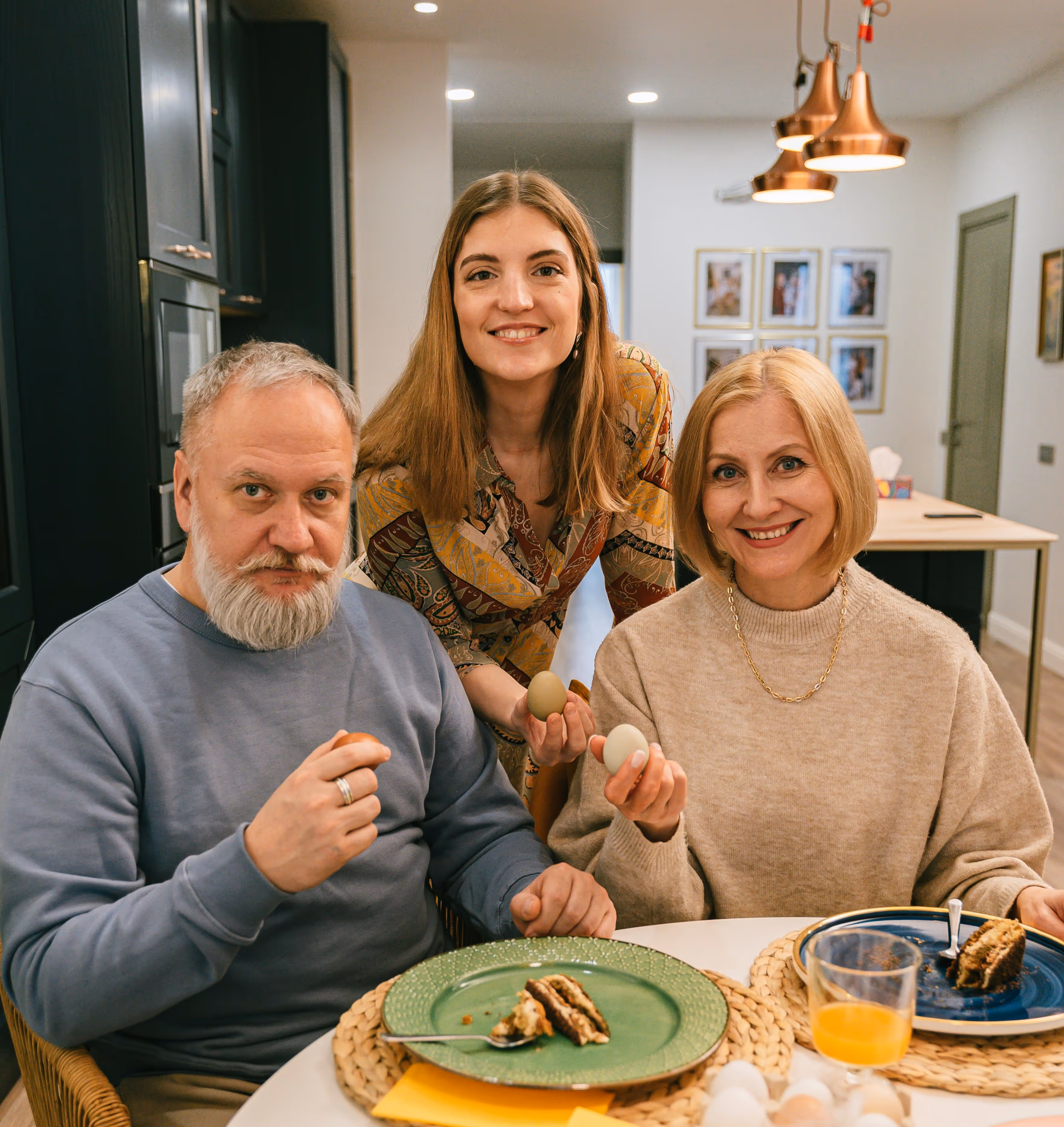 Adult daughter with her parents at home sharing a meal, representing family reunion and support for parent visa migration to Australia.
